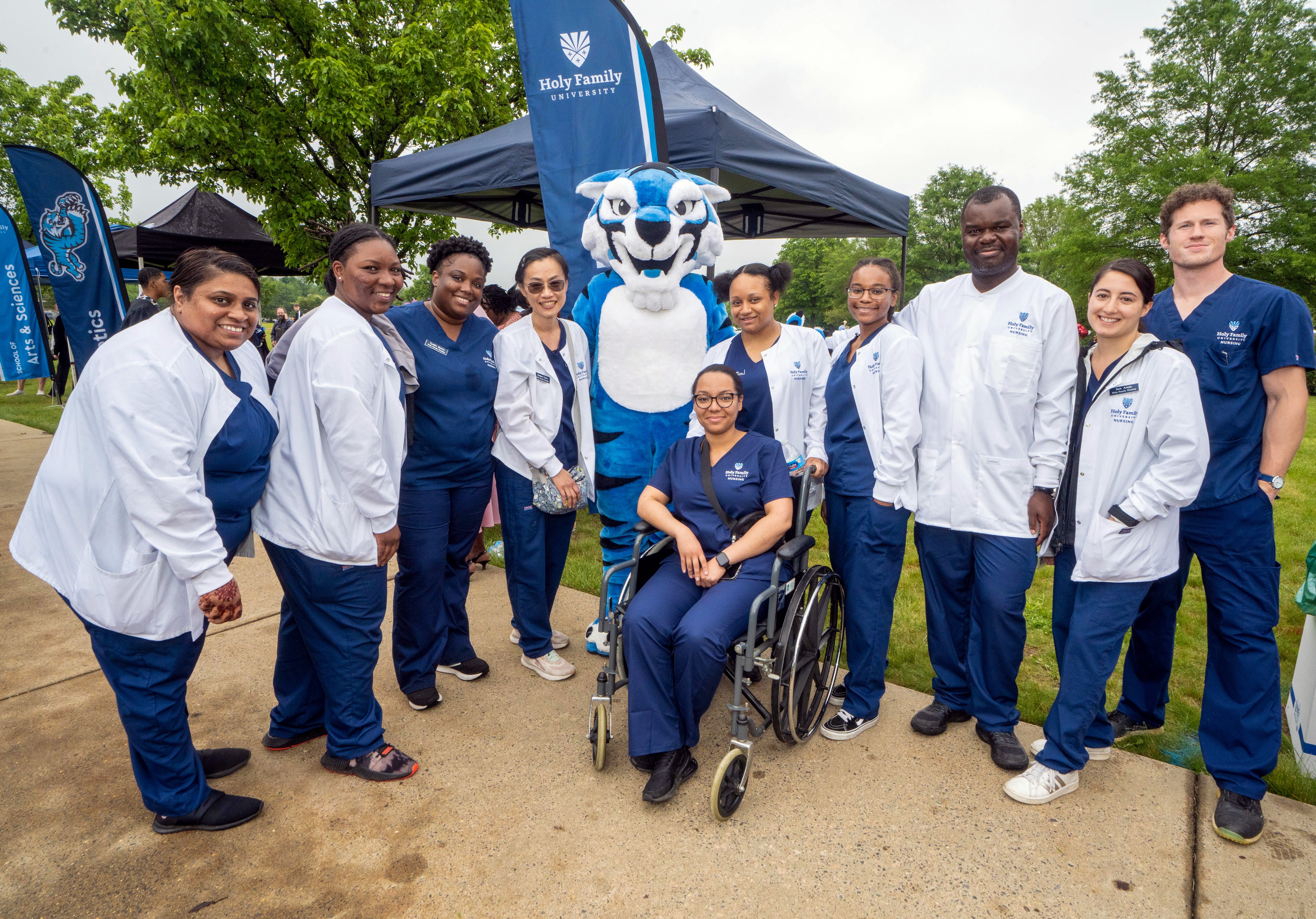 A group of Holy Family University nursing students pose for a photo with the university mascot