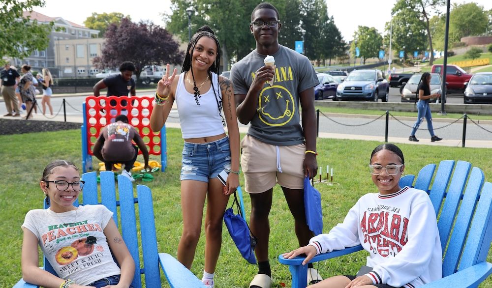 four Holy Family students hanging out on campus during an orientation event