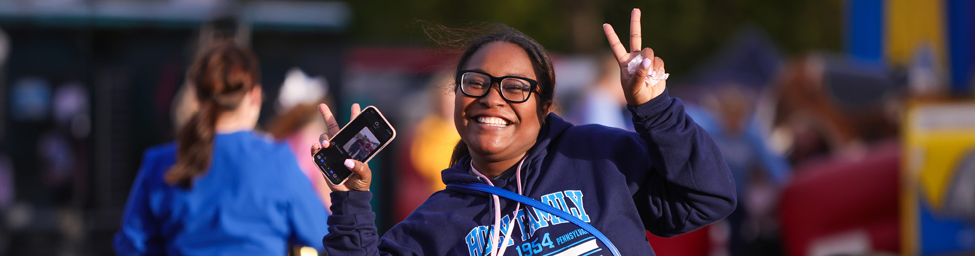 A Holy Family University transfer student smiling and flashing the peace sign