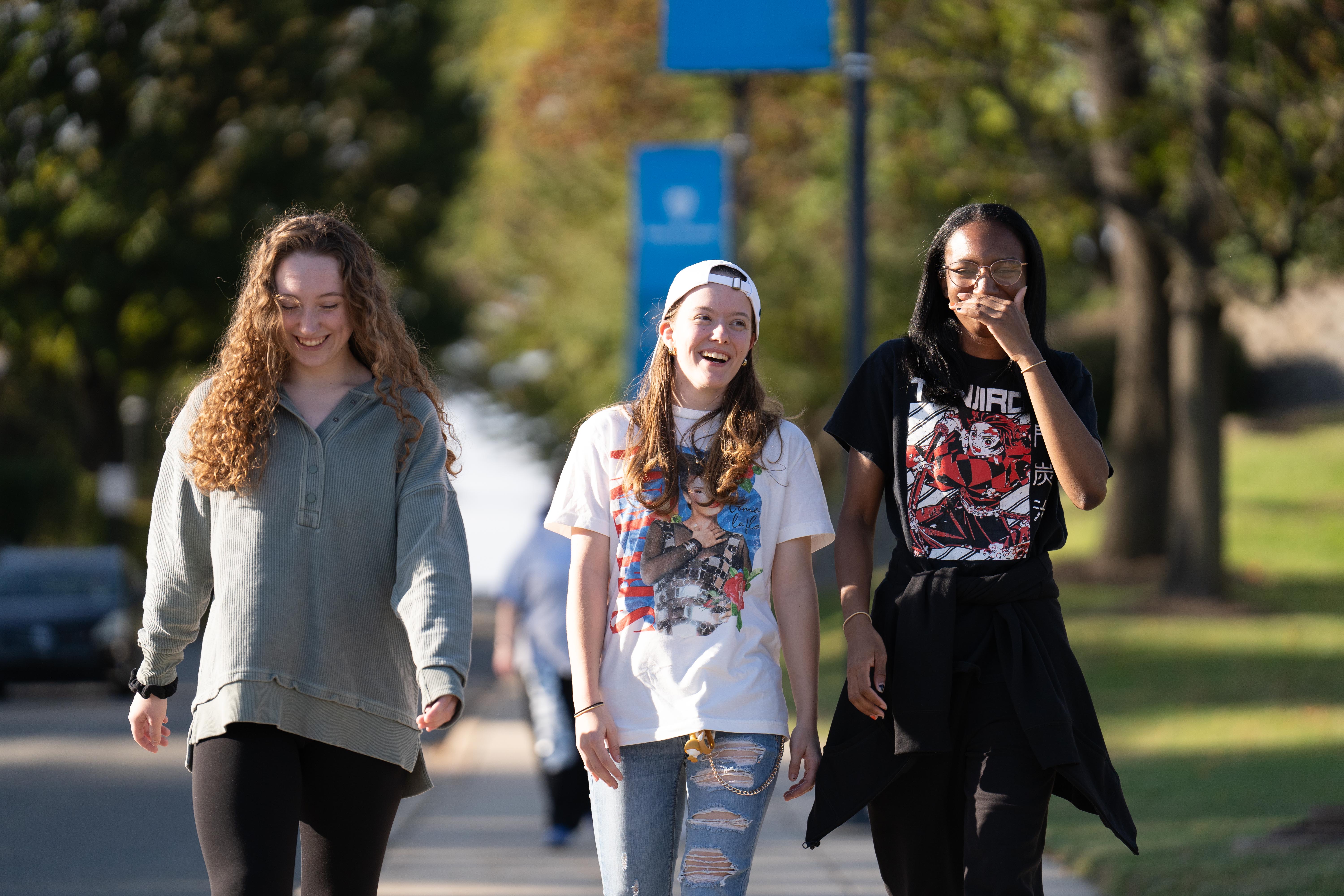 Three HFU students walking down a path on campus