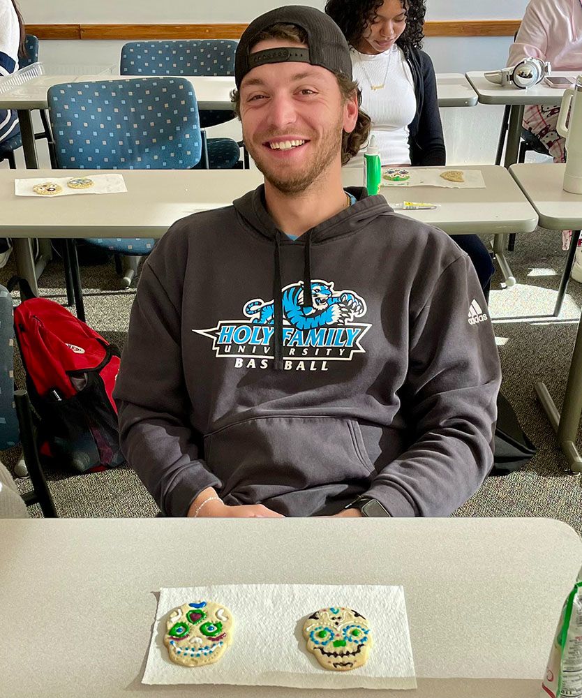 Student with two Day of the Dead cookies