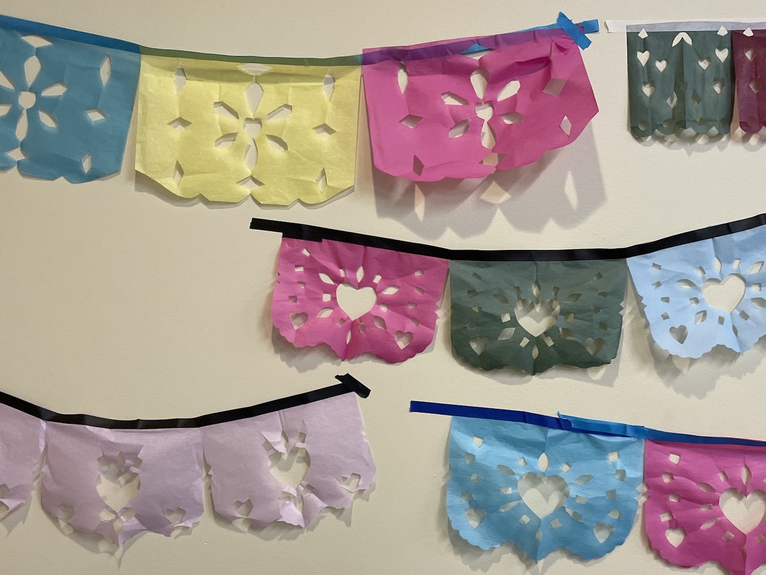 examples of students' papel picado work hung on the wall