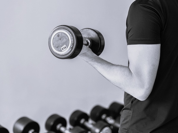 Person in a gym doing a bicep curl with a weight