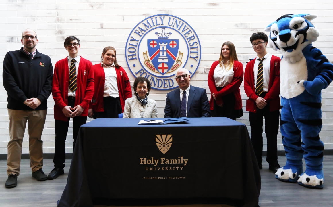 Anne Prisco, Ph.D., President of Holy Family University, and Joseph Sanginiti, president and chair of the Archbishop Ryan Board of Limited Jurisdiction, sign the educational agreement.