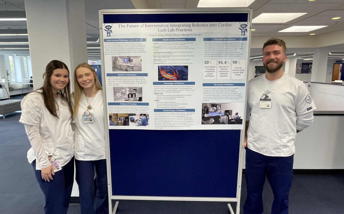 Students present poster on use of robotics in cath lab.