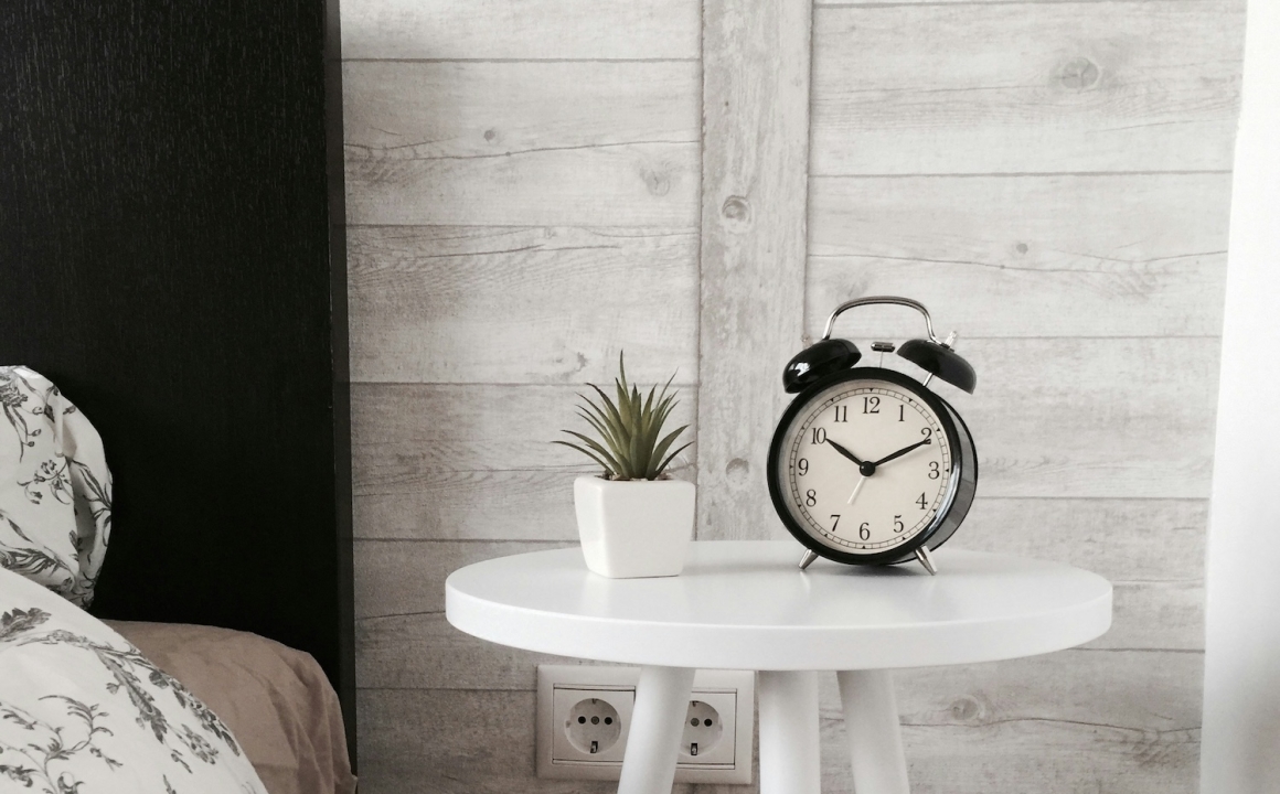 Analog alarm clock on bedside table