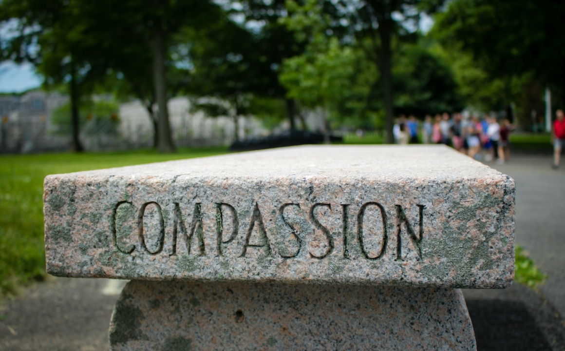 A marble outdoor bench with "Compassion" engraved in it