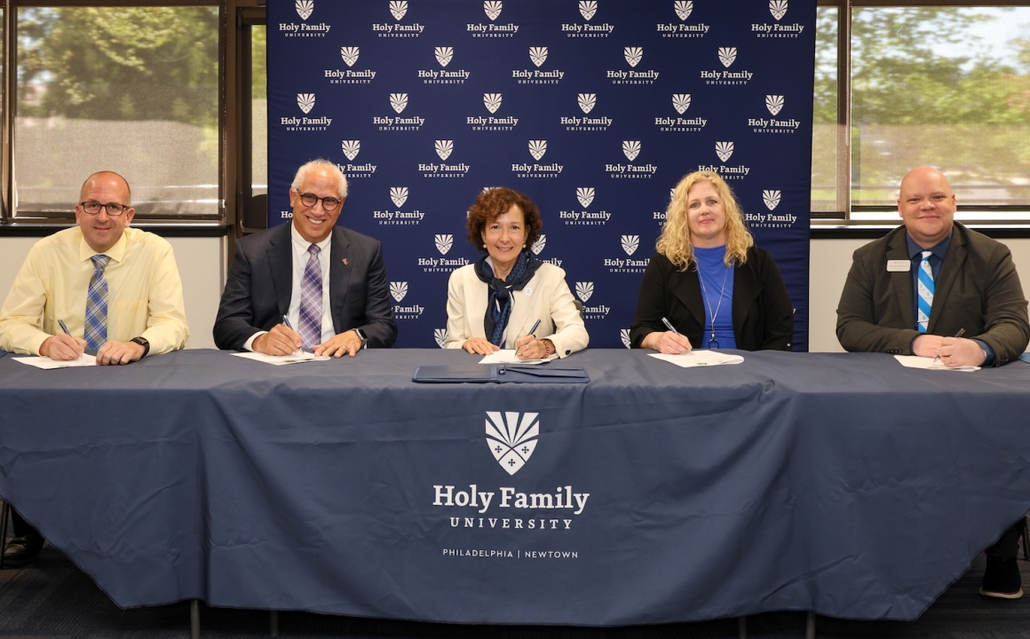 Representatives from Holy Family University and Archbishop Ryan signing their agreement