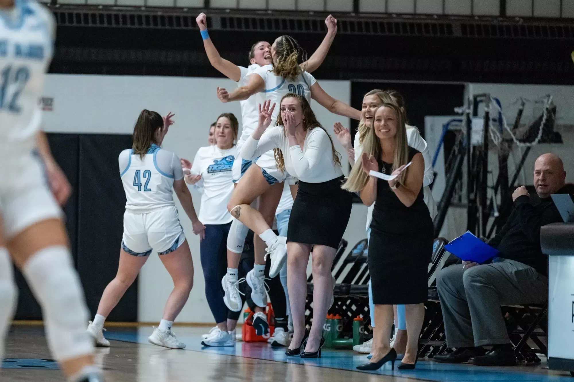 Members of women's basketball team celebrate after securing a victory