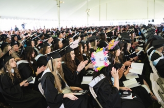 Audience of undergrad students in caps and gowns at Commencement