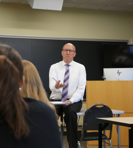 Faculty member lecturing to students in a Holy Family classroom