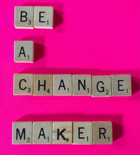 scrabble tiles that spell out "Be a Change Maker"