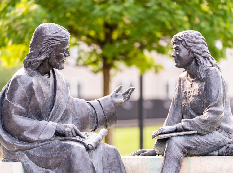 Jesus and a student on the bench statue