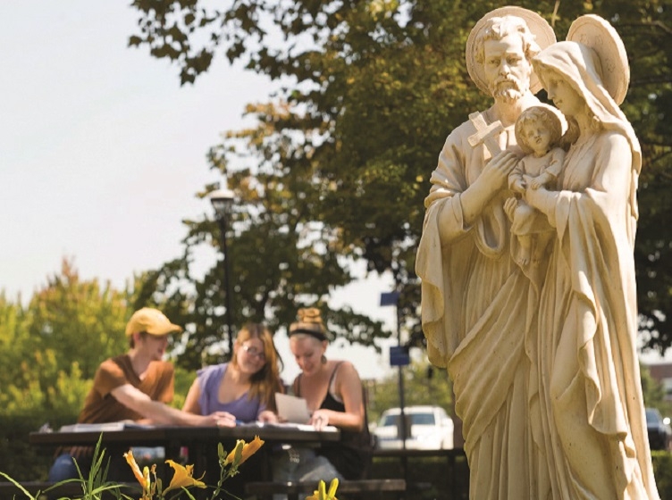 Statue of the Holy Family with students in the background