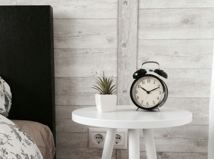 Analog alarm clock on bedside table