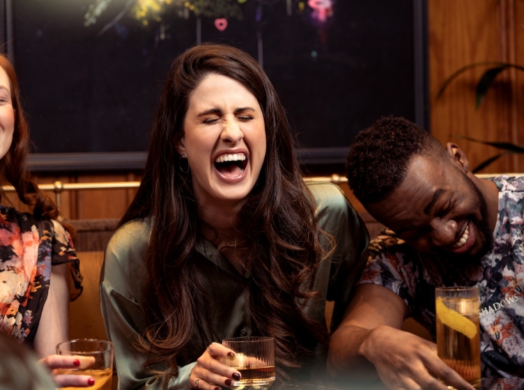 Three people sitting at a restaurant table laughing