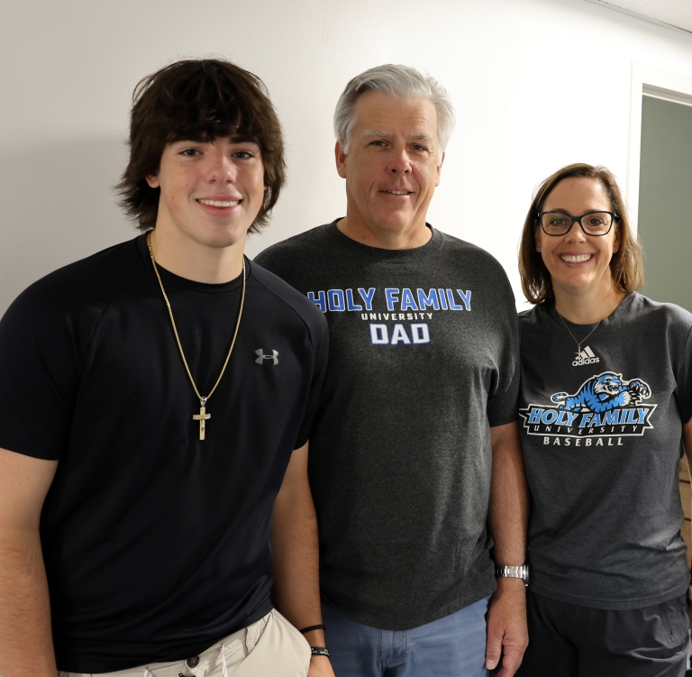 A Holy Family student and his parents smiling with the text 'Access the Parent Portal'