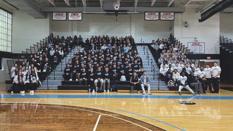 HFU student athletes sitting in stands of basketball court